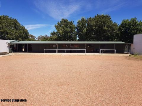Open gravel stage area in front of the Service range shelter