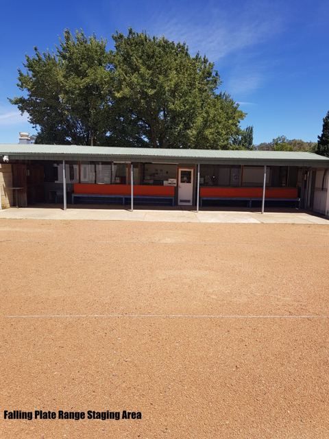 Covered staging area with benches beside the Falling Plate range